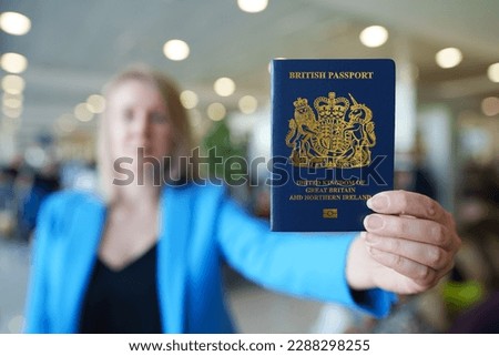 Woman showing passport of United Kingdom. Royalty-Free Stock Photo #2288298255