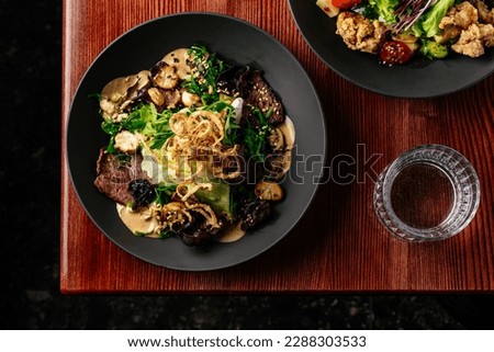 warm salad with beef, vegetables and herbs. restaurant menu Royalty-Free Stock Photo #2288303533