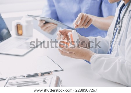 Dentists are discussing dental problems at report x-ray image on laptop screen to patients. Royalty-Free Stock Photo #2288309267