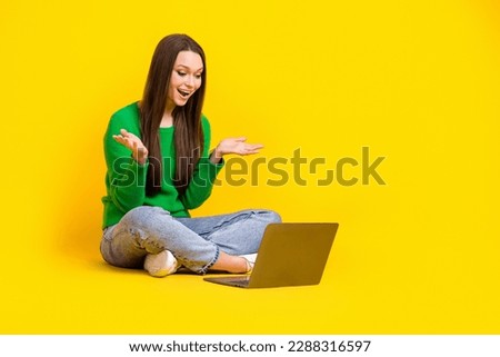 Full length photo of cute impressed lady dressed green pullover reading modern gadget emtpy space isolated yellow color background