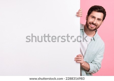 Photo of satisfied man hide behind white huge placard empty space looking camera enjoy new website app isolated on pink color background Royalty-Free Stock Photo #2288316983