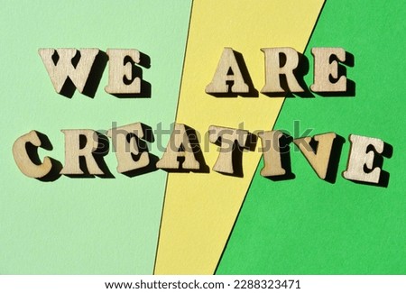We Are Creative, words in wooden alphabet letters isolated on green ad yellow background as banner headline