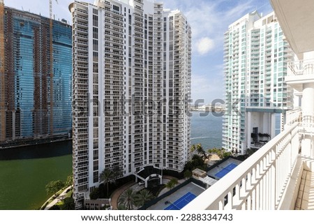 Balcony shot of Brickell Key area, with lots of towers and modern buildings, commercial urban landscape, surrounded by sea and canals, boats sailing, docks, bridges, avenues, blue sky