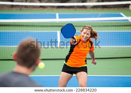 Female Pickleball player in action on an outside court Royalty-Free Stock Photo #228834220