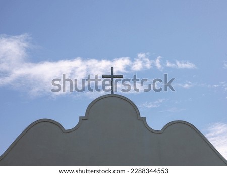 View of top of catholic church building with cross and sky background. Catholic church at Old Town San Diego.