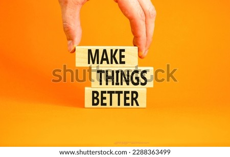 Make things better symbol. Concept words Make things better on wooden block on a beautiful orange table orange background. Businessman hand. Business and make things better concept. Copy space.