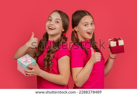 glad kids with present boxes on red background Royalty-Free Stock Photo #2288378489