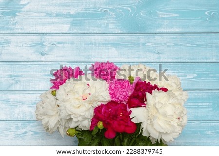 Beautiful background with peony flowers. Spring template billboard, web banner, flyer to women's day, mother's day, anniversary. Bouquet of peonies flowers on light blue wooden background.