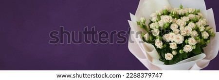 Panoramic header background for women's day, mother's day. Bouquet of light roses flowers on dark purple background. Beautiful wide template with copy space for design web banner, flyer, greeting card