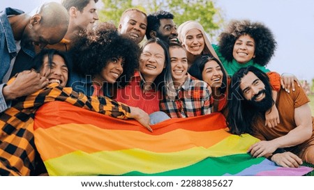 Happy diverse people holding lgbt rainbow flag outdoors - Diversity concept - Soft focus on Asian young woman face Royalty-Free Stock Photo #2288385627