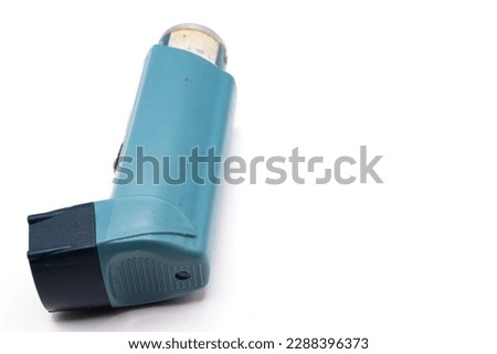 Blue asthma inhaler with blank label isolated on white background. Pharmaceutical product is used to treat or prevent asthma attack. Health and medical concept. Royalty-Free Stock Photo #2288396373