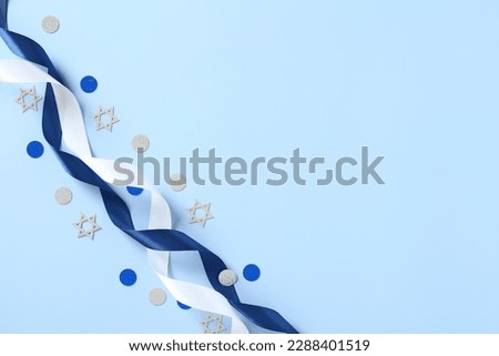 Blue and white ribbons with confetti on blue table. Israel Independence Day, Yom Haatzmaut greeting card design, banner template. Royalty-Free Stock Photo #2288401519