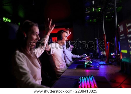 young people play in a computer club together and rejoice in victory, team play cyber sports game Royalty-Free Stock Photo #2288413825