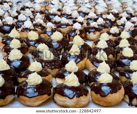 Fresh donuts, covered by dark chocolate at the bakery for Hanukkah celebration.