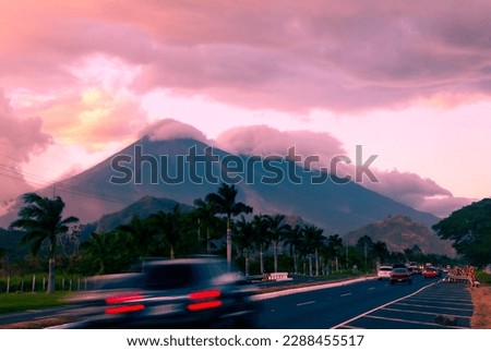 Palin Escuitla highway at sunset in Guatemala, Central America, passenger and cargo transport area, cloud covered volcanoes in the background.