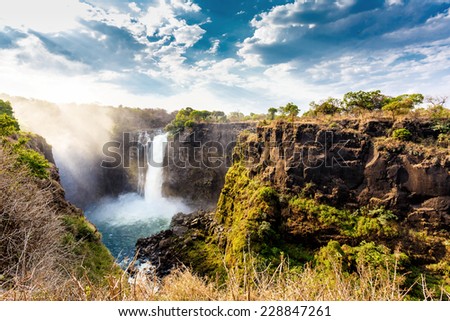 The Victoria falls is the largest curtain of water in the world (1708 meters wide). The falls and the surrounding area is the National Parks and World Heritage Site - Zambia, Zimbabwe  Royalty-Free Stock Photo #228847261
