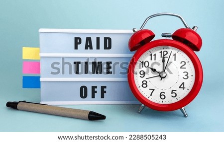 Text Paid Time Off written on the lightbox with alarm clock and colorfull stickers on blue background Royalty-Free Stock Photo #2288505243
