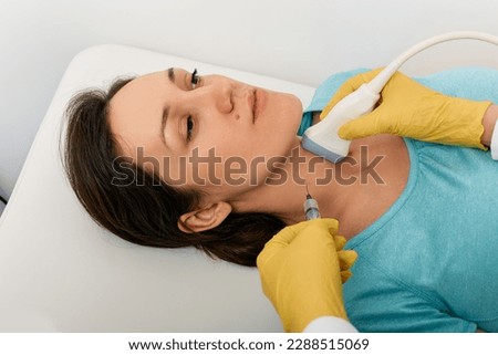 Thyroid nodule biopsy. Adult woman during fine needle aspiration biopsy guided ultrasonic and ultrasound specialist Royalty-Free Stock Photo #2288515069