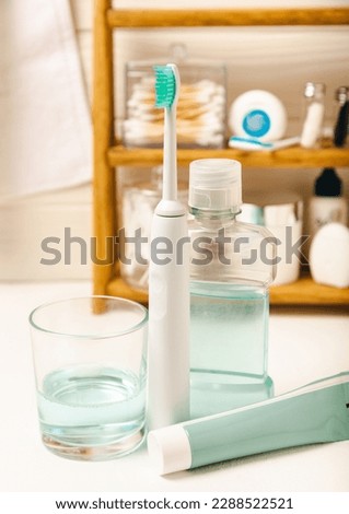 Modern sonic or electric toothbrush with charger in the bathroom. The concept of professional oral care and healthy teeth. Place for text. Close-up. Minimal design. Fresh breath. Healthy teeth.