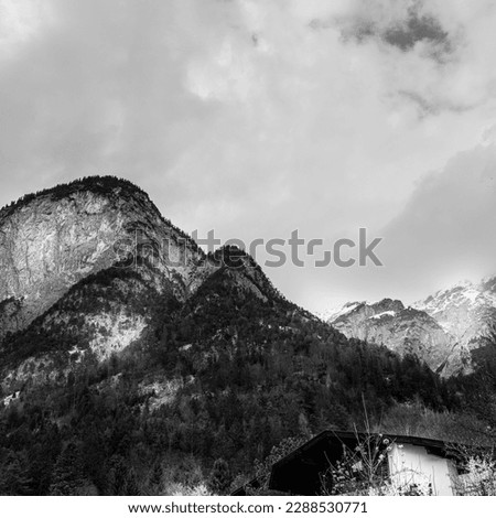 High mountains of the Alps of Nordkette, also called the North Chain or Northern Range in Innsbruck, Tyrol, Austria, dramatic black and white cloudscape with rain in the springtime