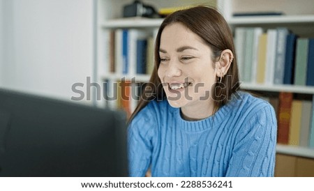 Young caucasian woman student using computer studying at library university