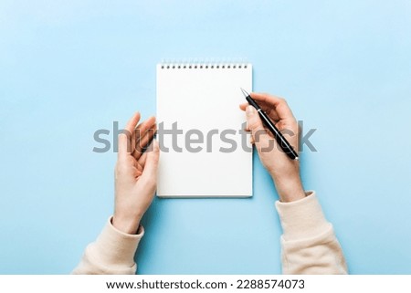 Woman hand with pencil writing on notebook. Woman working on office table. Female hand holding pencil and sketchbook. Mock-up Concept. Royalty-Free Stock Photo #2288574073