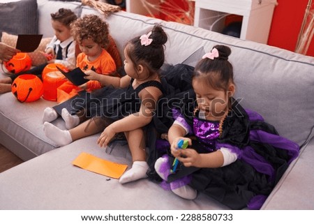 Group of kids wearing halloween costume cutting paper at home