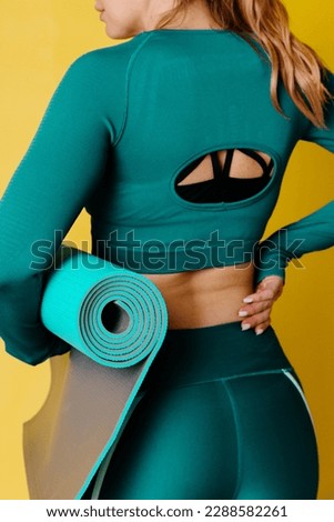 Woman holding yoga mat. Preparation for the practice of yoga and Pilates. For yoga classes, yoga teachers, meditation, relaxation, balance training. Bright model and background