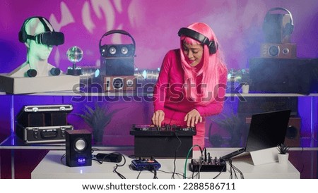 Cheerful dj mixing and mastering electronic sound using professional turntables, enjoying performing music during night party in club. Asian artist doing performance with audio equipment
