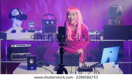 Performer recording music session with smartphone camera, mixing and mastering electronic sound preparing eletronic concert. Musician performing techno song using professional audio equipment