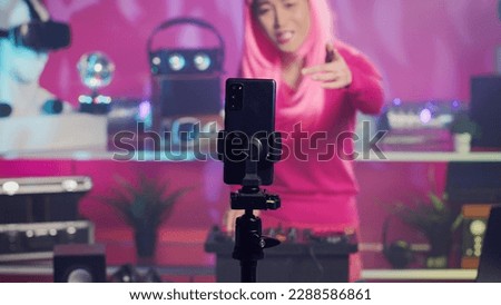 Musician recording music session with phone camera, mixing and mastering electronic sound preparing eletronic album. Artist performing techno song using professional audio equipment