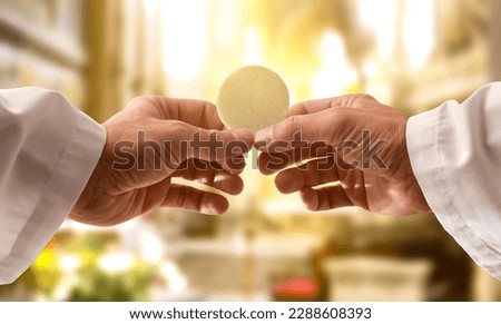Hands of a priest consecrating a host as the body of Christ to distribute it to the communicants in the church Royalty-Free Stock Photo #2288608393