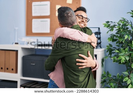 Two men business workers hugging each other at office Royalty-Free Stock Photo #2288614303