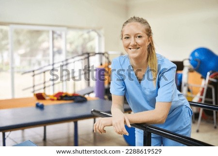 Smiling young woman as physiotherapist standing in gym of nursing home Royalty-Free Stock Photo #2288619529