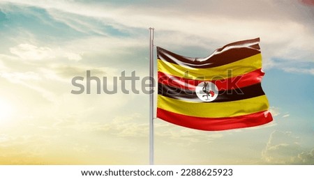 Waving flag of Uganda in beautiful sky. Uganda flag for independence day. Royalty-Free Stock Photo #2288625923