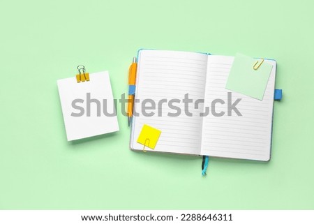 Sticky notes and notepad on green background