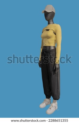 Full length image of a female mannequin wearing fashionable sportswear isolated on blue background