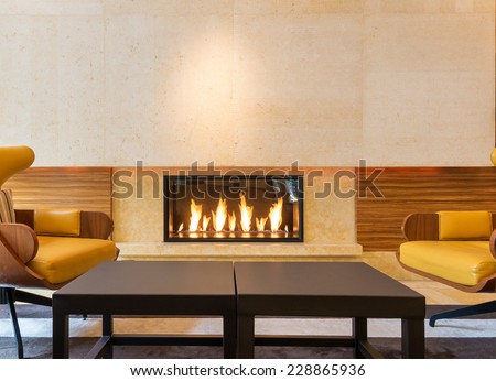 Modern fireplace sitting area with two leather chairs. Interior design.