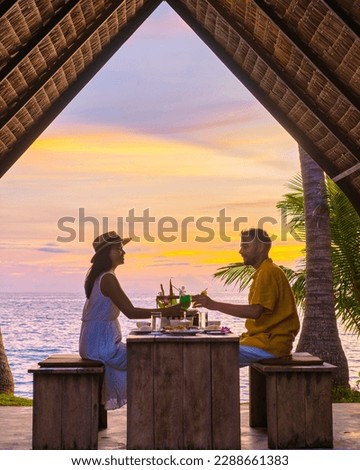 Romantic dinner on the beach with Thai food during sunset on the Island of Koh Mak Thailand. Couple of men and women having a romantic dinner on the beach Royalty-Free Stock Photo #2288661383