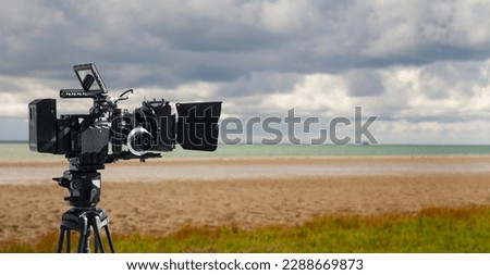 A digital movie camera filming a shot of nature by the sea.  Wildlife movie or documentary film banner with copy space. Royalty-Free Stock Photo #2288669873