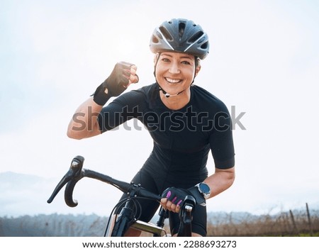 Fitness, celebration and portrait of woman cycling with power fist, success or victory in the countryside. Happy, sports and face of lady cyclist celebrating workout achievement, milestone or winning Royalty-Free Stock Photo #2288693273