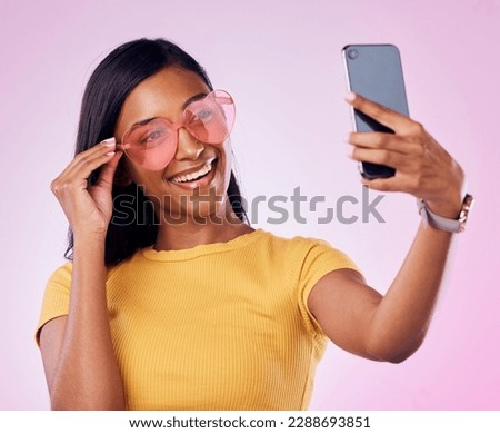 Sunglasses, selfie and happy Indian woman on pink background with cosmetics, confidence and beauty. Fashion, summer style and girl in studio take picture for social media, post and influencer blog