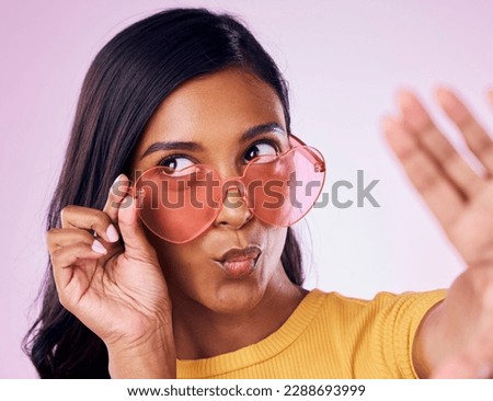 Selfie, heart and sunglasses by indian woman in studio emoji, cool and fun on purple background. Glasses, trendy and female gen z fashion influencer posing for profile picture, photo or blog post