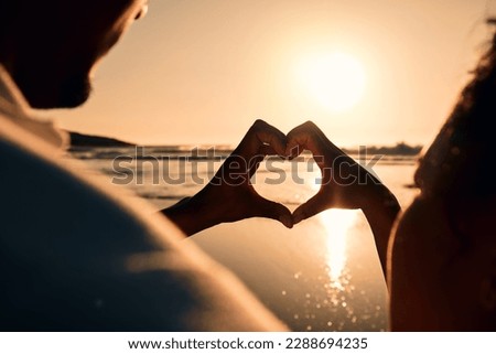 Sunset, beach and couple with a heart symbol while on a vacation, adventure or weekend trip. Romance, silhouette and closeup of man and woman with love hand gesture in the evening on romantic holiday