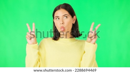 Green screen, funny face expression and happy woman posing with tongue out, peace sign and carefree personality. Portrait, female model and smile in studio with emoji reactions, meme and happiness