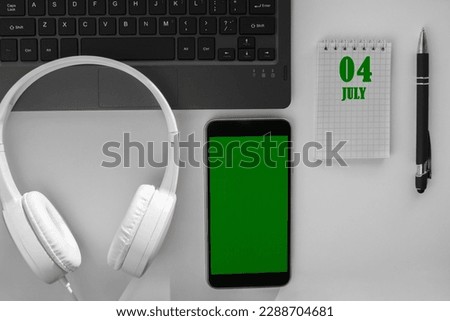 calendar date on a light background of a desktop and a phone with a green screen.  July 4 is the fourth day of the month.