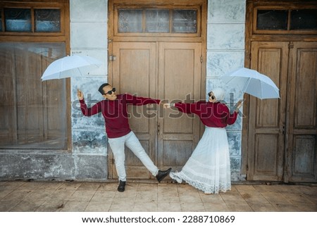happy couple with umbrella on the street