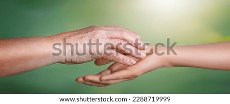Young woman hands holding elderly hands with clipping path on green autumn background. Royalty-Free Stock Photo #2288719999