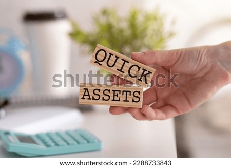 Quick Assets Word Written on Wooden Block in Hand With Cap Coffee and Calculator.