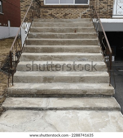 This photo shows a deteriorating exterior concrete staircase with rust stains and cracks, requiring specialized high-strength rust-inhibiting cement resurfacing to restore its appearance and function.